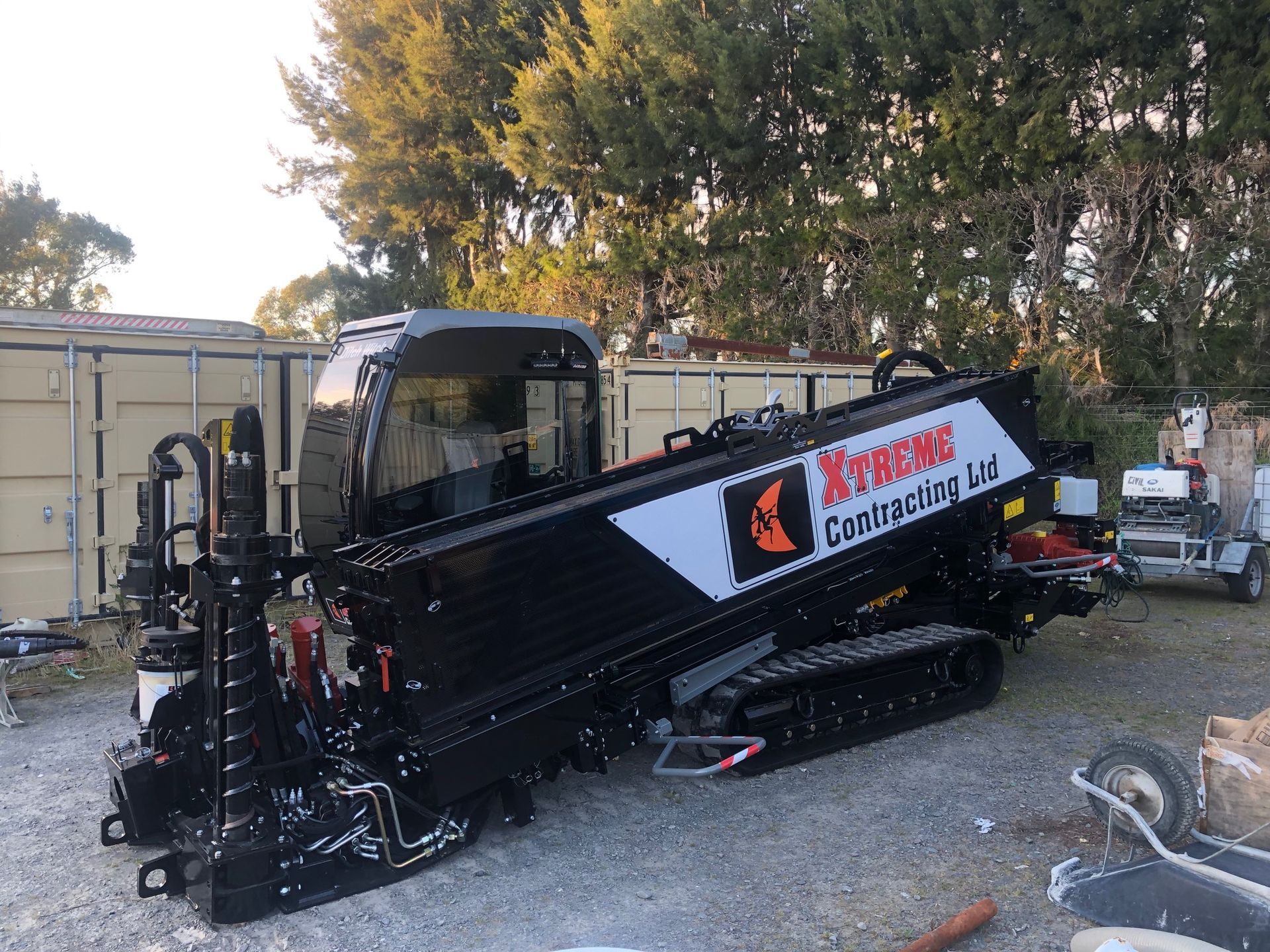 A black and white machine is parked in a gravel lot.