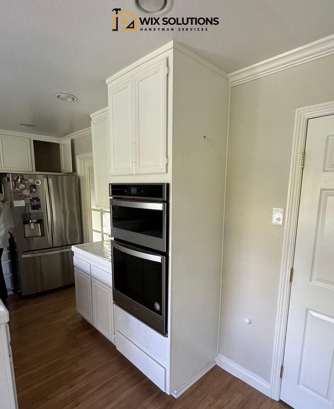 A kitchen with white cabinets and stainless steel appliances.