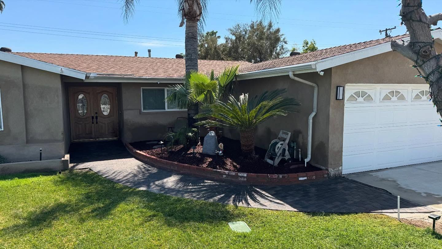 A house with a white garage door and a palm tree in front of it.