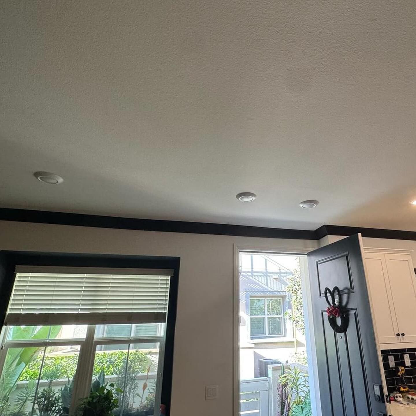 A kitchen with a blue door and a wreath on the door.
