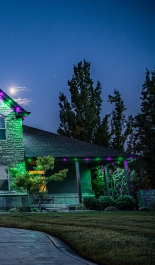 Person wiring an electrical outlet into a blue box in a wall during construction.