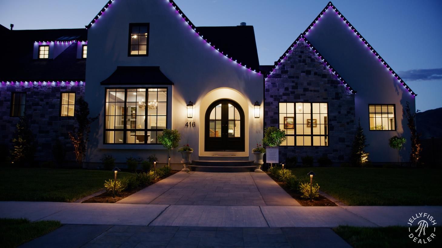Electrician working on a wall outlet, wearing red gloves and a tool belt. A multimeter and safety helmet are nearby.