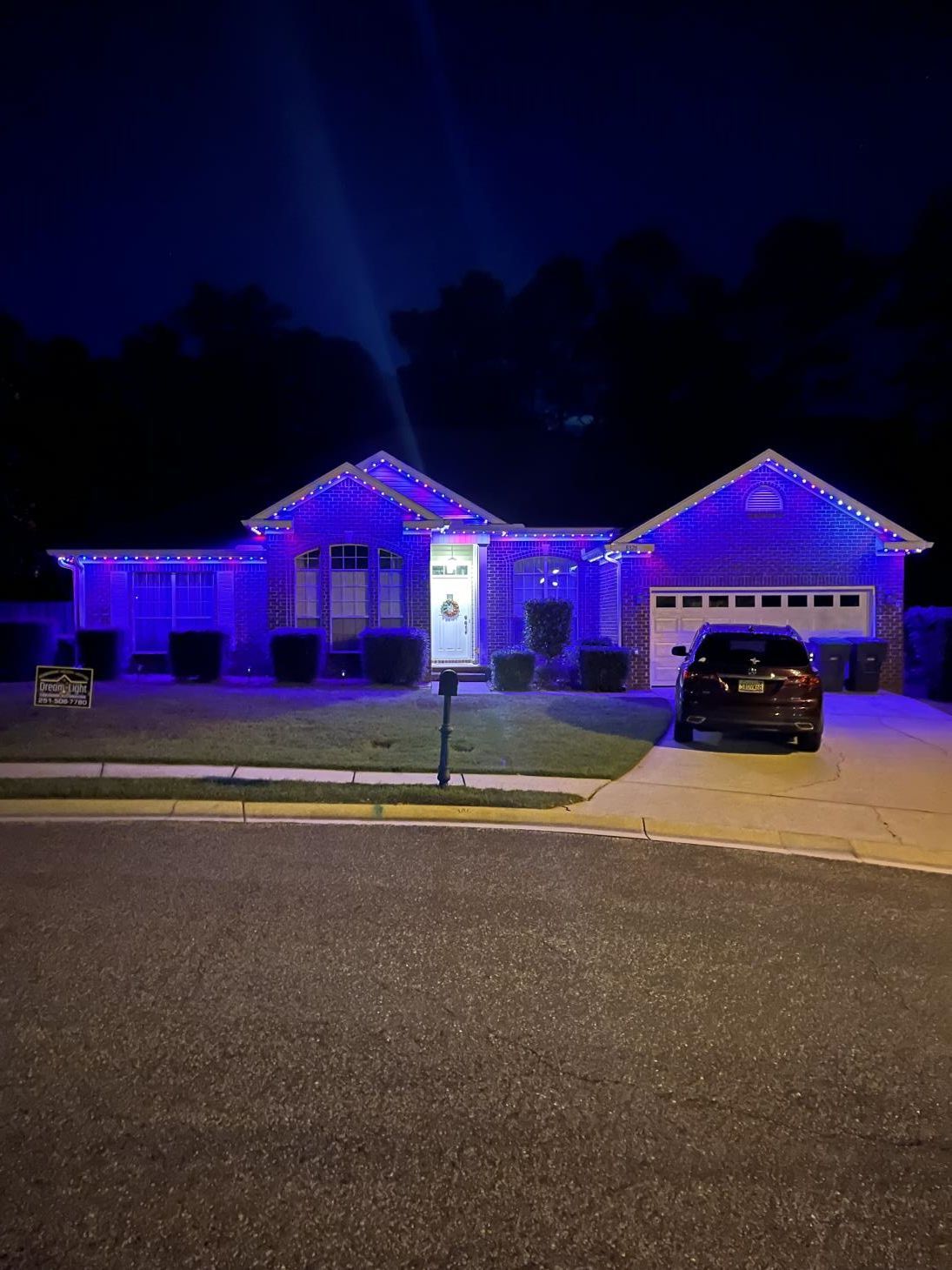 Person installing electrical outlet with a drill in a white wall.