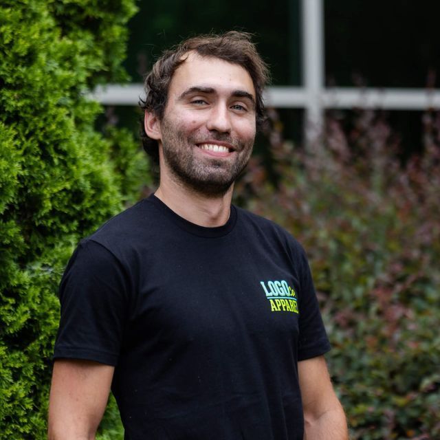 A man wearing a black t-shirt with the word logo on it