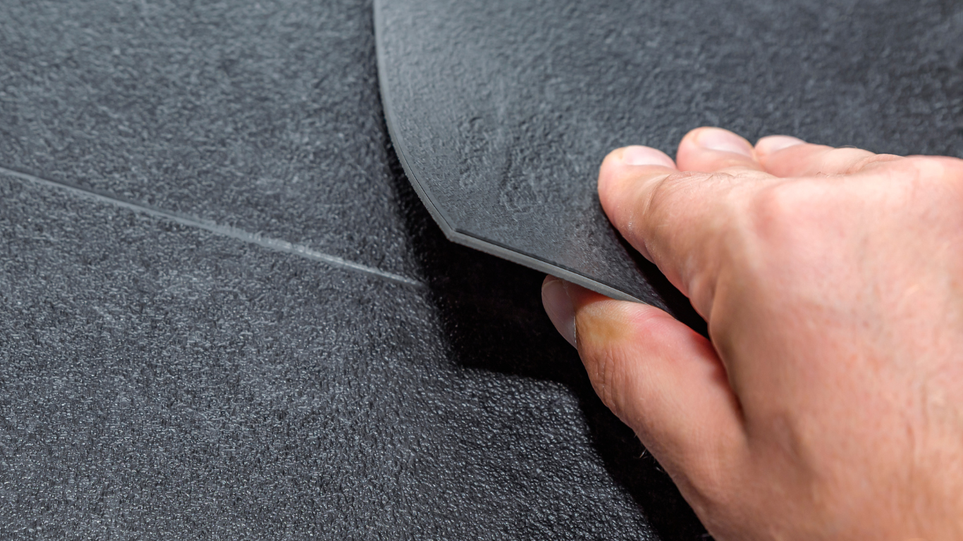 A person is holding a piece of black foam in their hand.