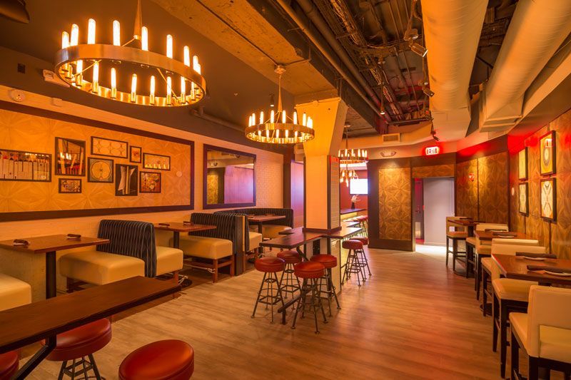 A restaurant with tables and chairs and a chandelier hanging from the ceiling.