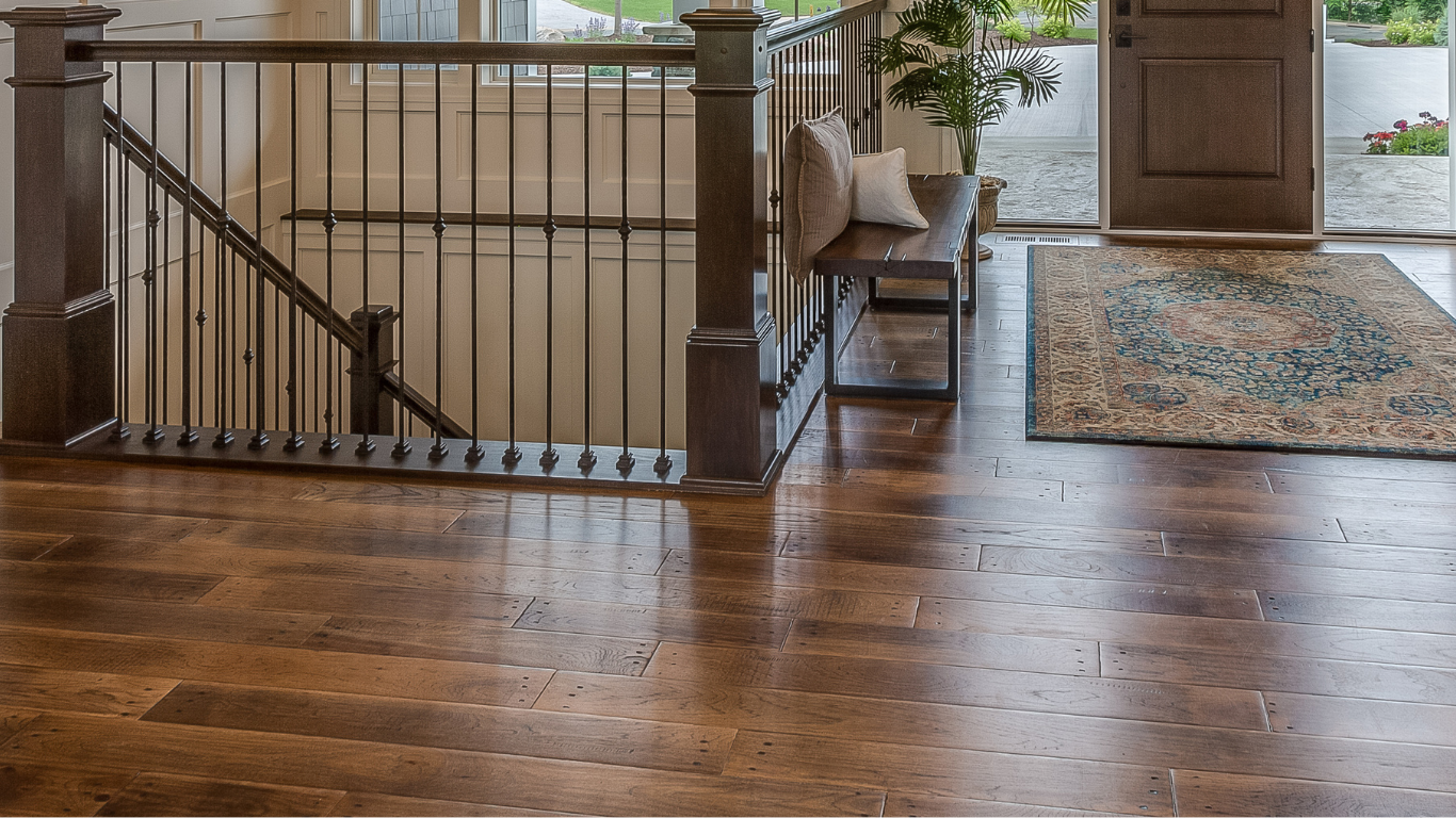 There is a staircase in the middle of the room with a wooden floor.