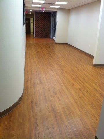 A long hallway with wooden floors and white walls.