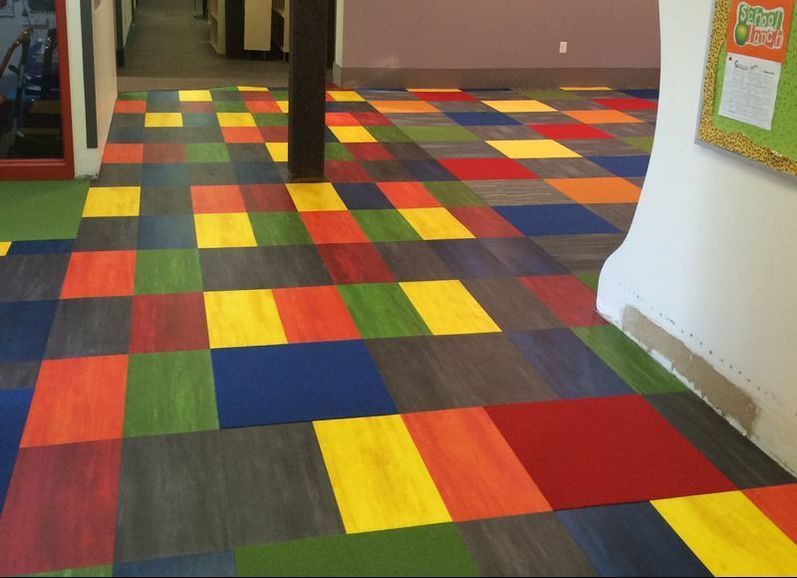 A colorful carpeted floor in a hallway with a calendar on the wall