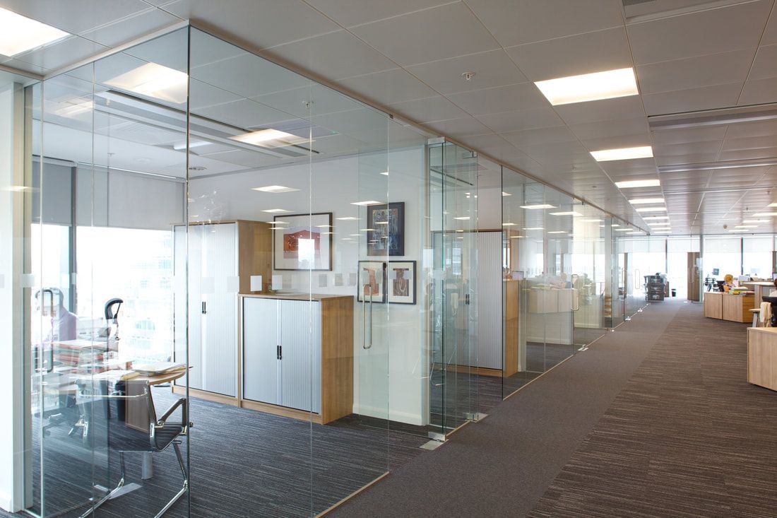 A large office with a lot of glass walls and doors.