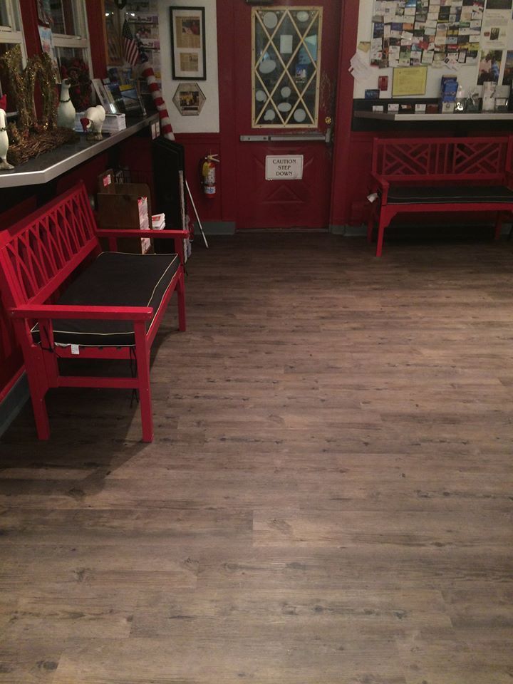A waiting room with a red bench and two red chairs