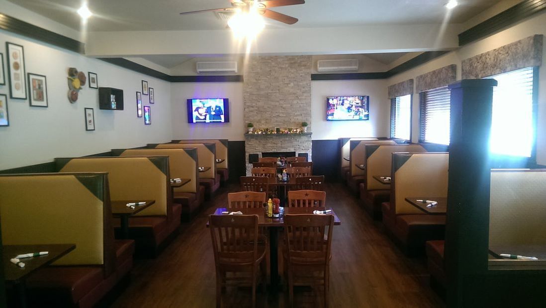 A restaurant with tables and chairs and a ceiling fan