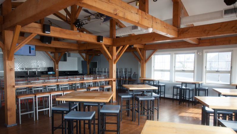 A restaurant with wooden beams and tables and chairs
