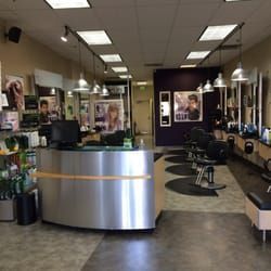 The inside of a hair salon with a stainless steel counter and chairs.
