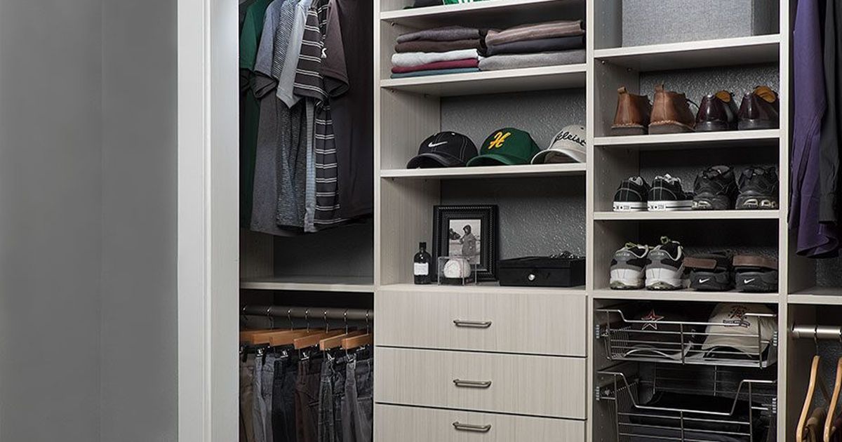 Customized closet organizer with clothes, shoes, hats, and drawers; neutral tones.