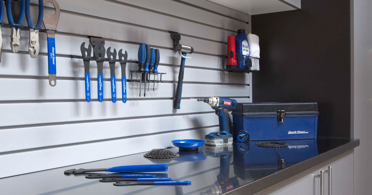 Garage with gray and white cabinets, a countertop, a TV, and a wall-mounted organization system.