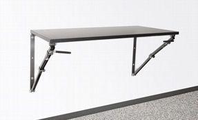 Wall-mounted folding shelf bracket supporting a gray shelf against a white wall