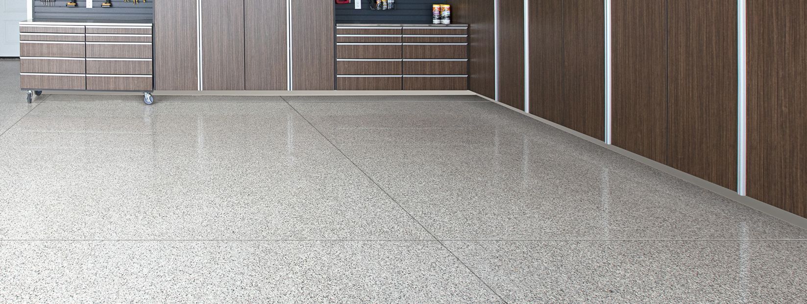 Empty speckled floor in a modern indoor walkway with wooden walls and a gated entrance.