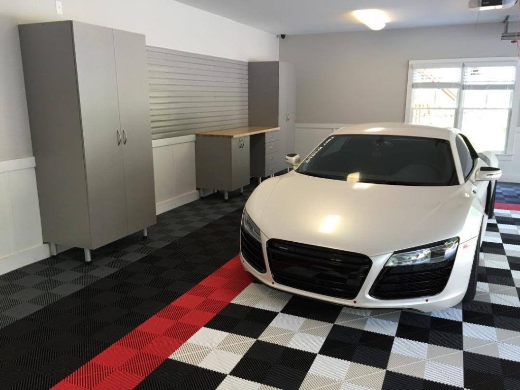 White sports car in a garage with black-and-white checkered flooring and gray storage cabinets