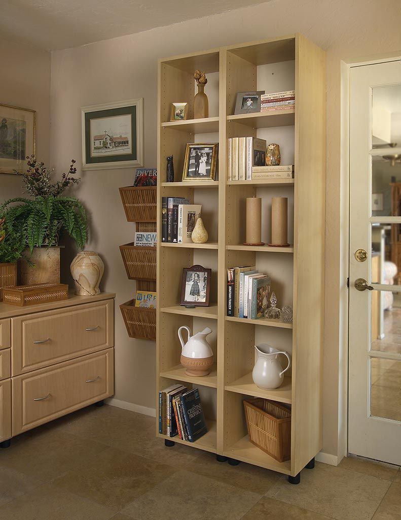 Wooden shelving unit with baskets and jars in a home hallway beside a glass door