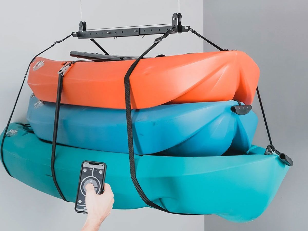Hand-held remote controls three stacked inflatable boats strapped to a roof rack
