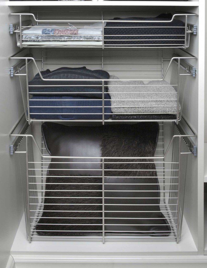 Wire rack shelving holding folded blankets and bins inside an open closet.