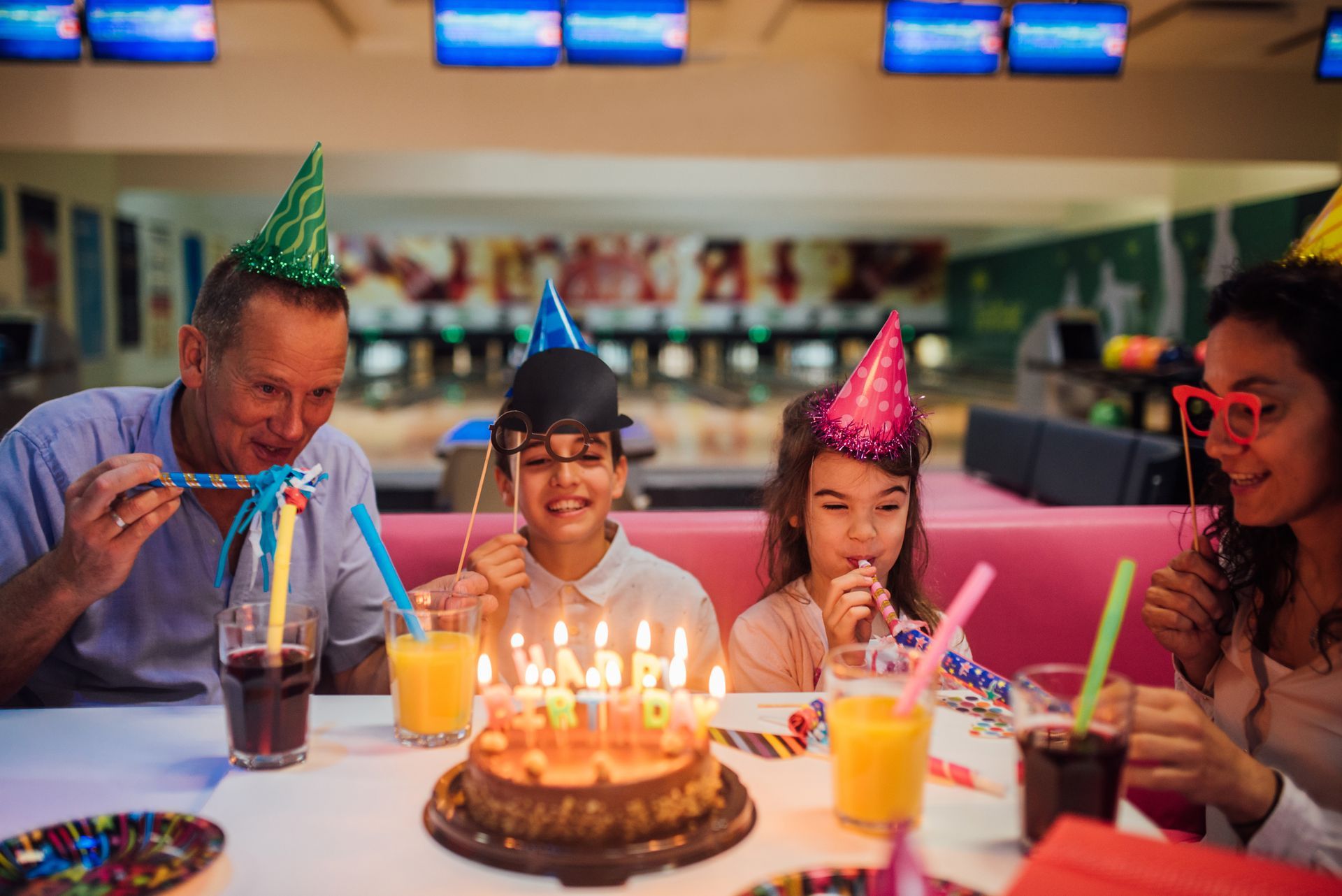 Family celebrating birthday together featuring bowling lanes and festive decorations for a fun and m