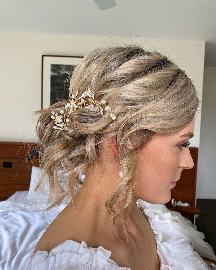 A Woman with Blonde Hair in A Bun Is Sitting on A Bed — Rowe Street Collective In Shepparton, VIC