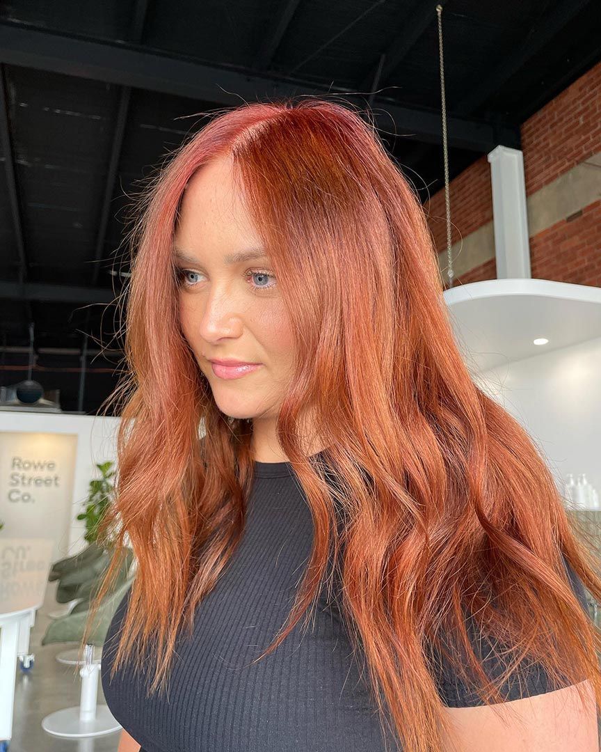 A Woman with Long Red Hair Is Wearing a Black Shirt — Rowe Street Collective In Shepparton, VIC