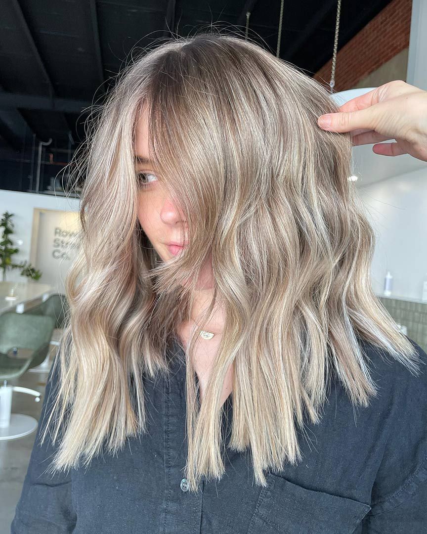 A Woman with Long Blonde Hair Is Getting Her Hair Done in A Salon — Rowe Street Collective In Shepparton, VIC
