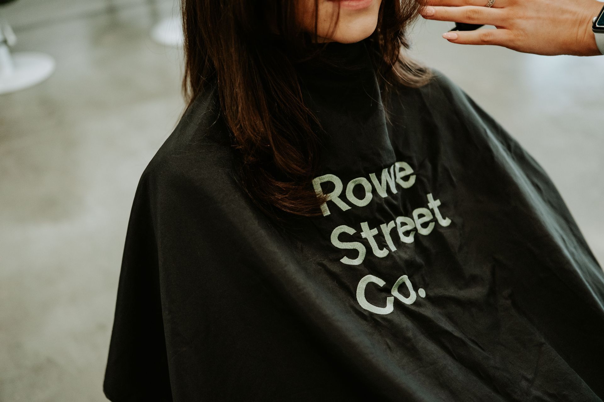 A woman is getting her hair cut by a hairdresser in a salon. — Rowe Street Collective In Shepparton, VIC