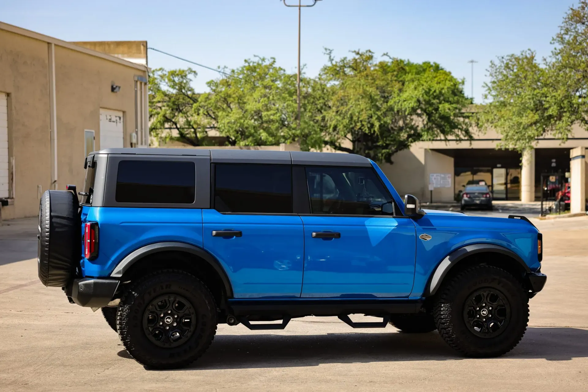 Blue Ford Bronco with black accents parked on pavement.