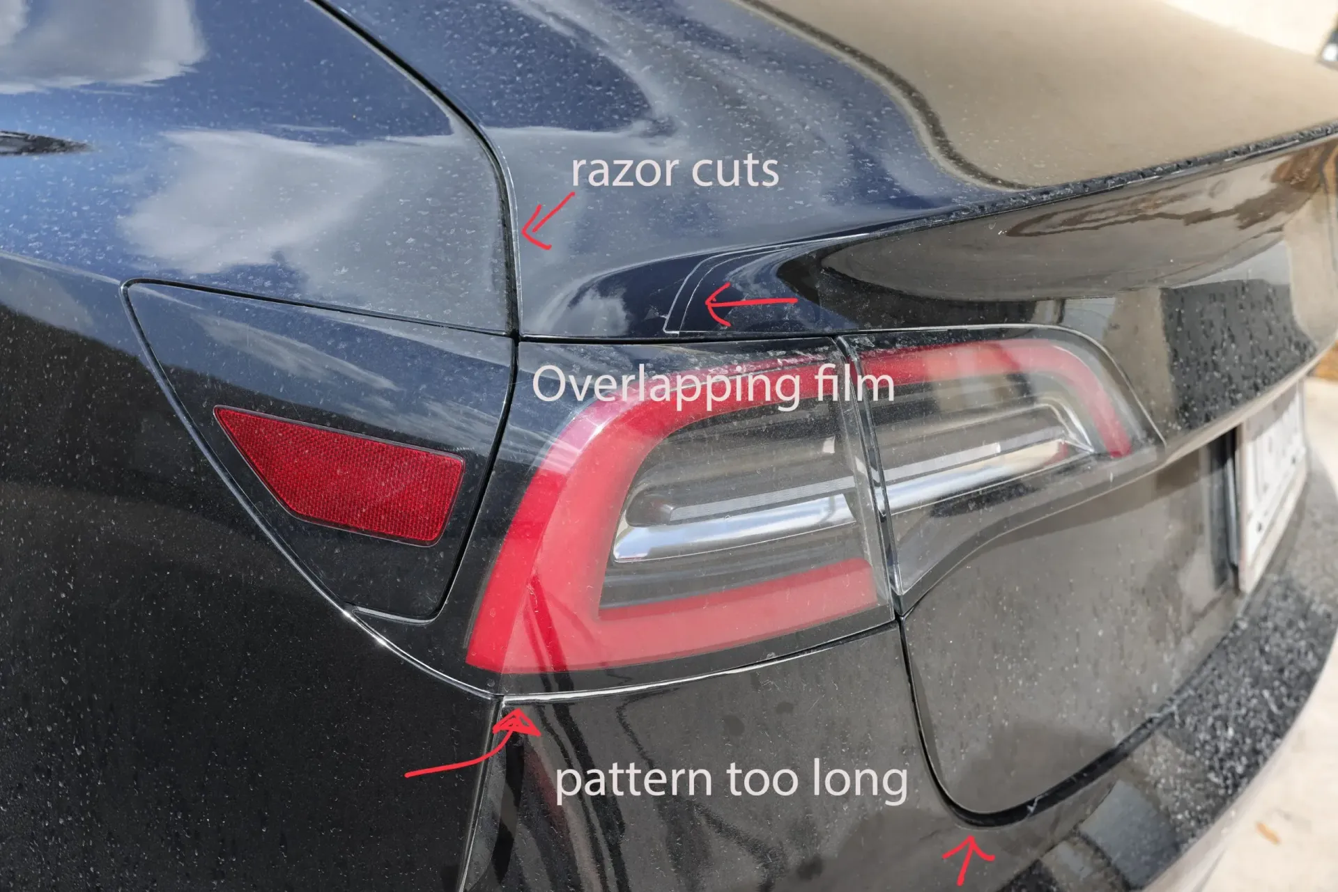 Close-up of a dark car's rear, showing film installation flaws: razor cuts, overlapping film, and pattern too long.