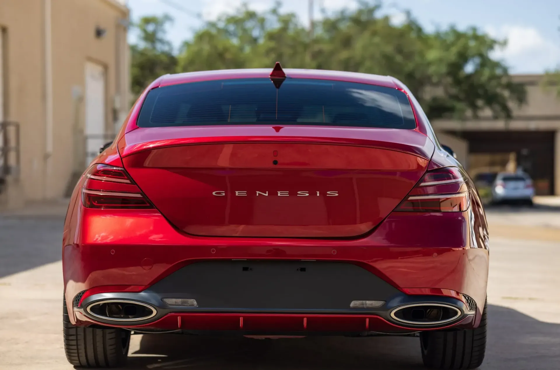 Red Genesis sedan, rear view, with dual exhaust.