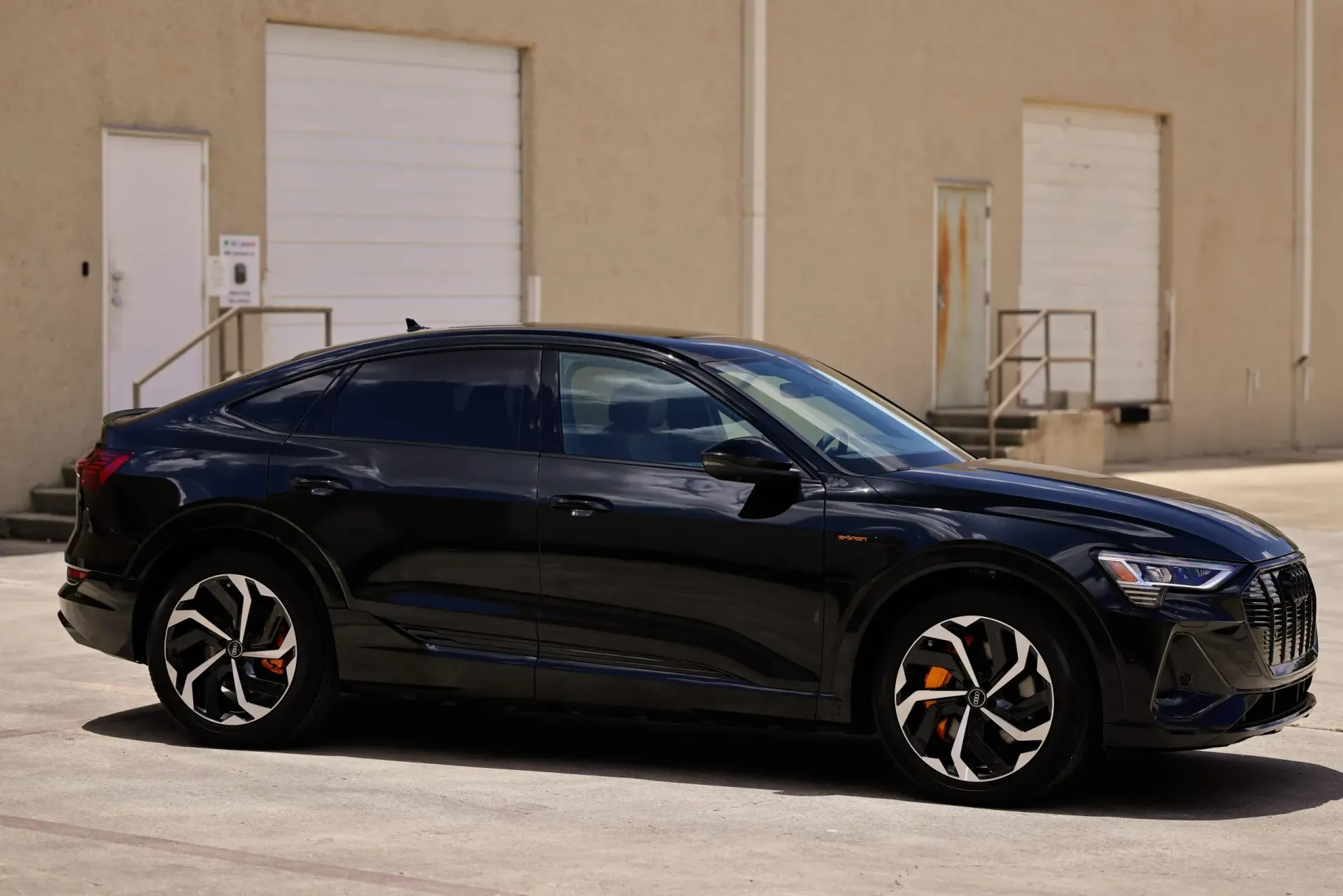 Black Audi e-tron SUV parked outdoors, showcasing its sleek design.
