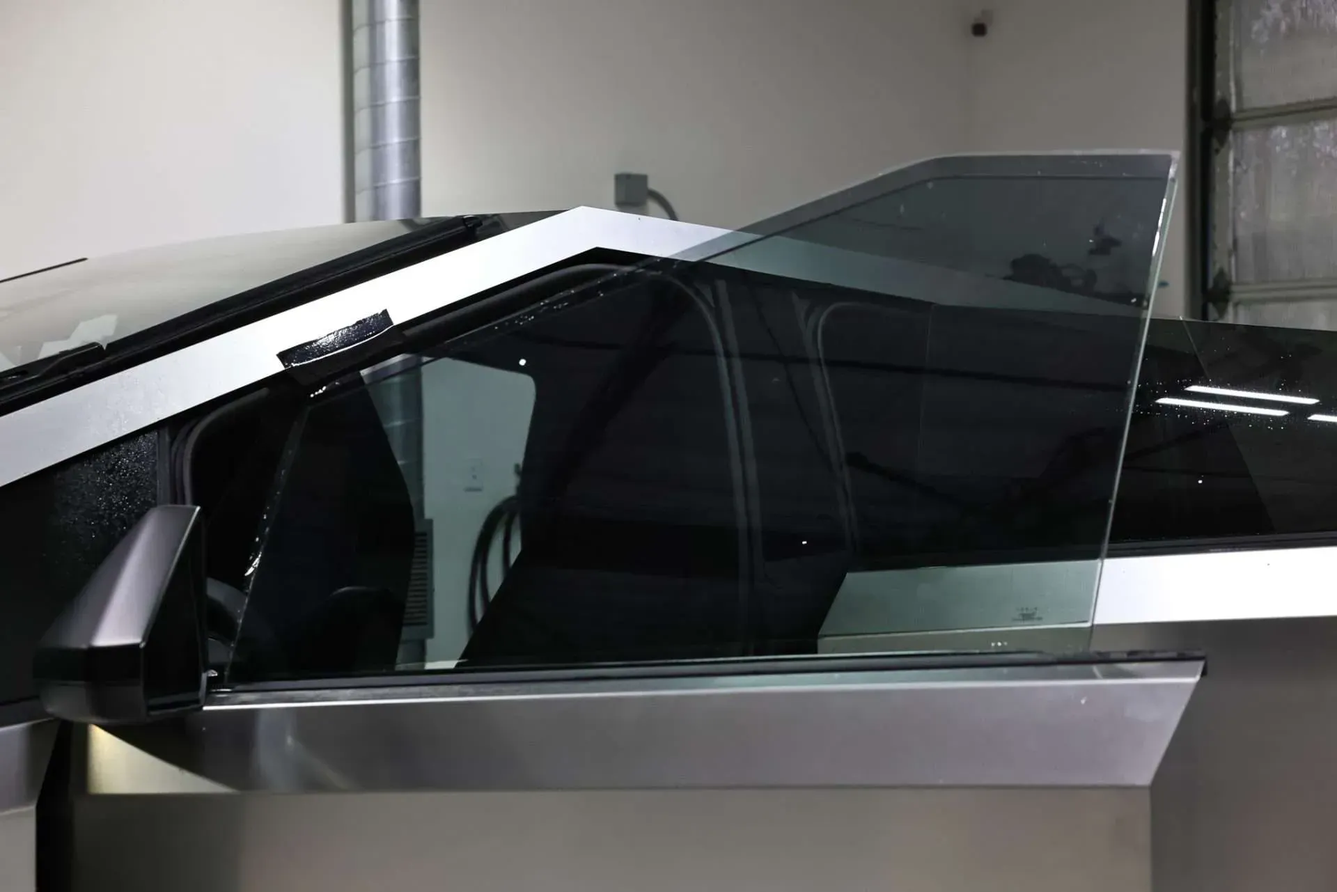 Side view of a vehicle's door with tinted windows, showcasing the design in a modern setting.