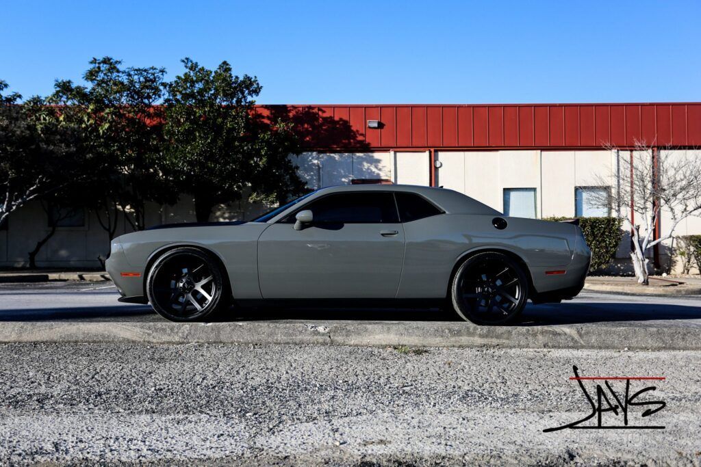 Gray Dodge Challenger parked on a street with a building in the background.