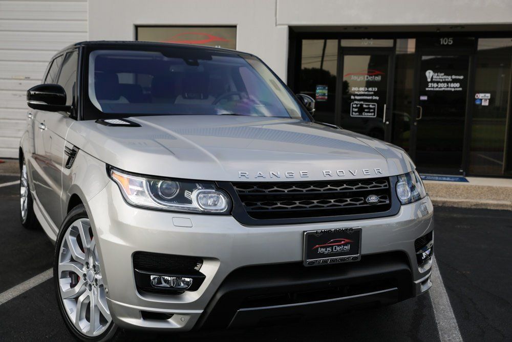 Silver Range Rover Sport parked in front of a building with glass doors.