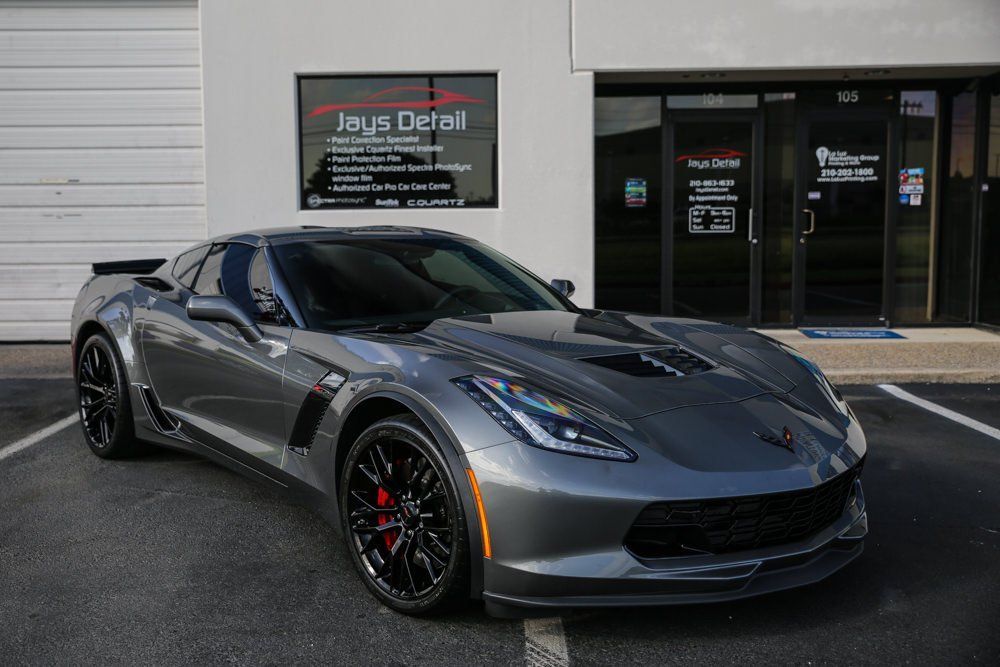 Gray Corvette sports car parked in front of Jay's Detail shop.