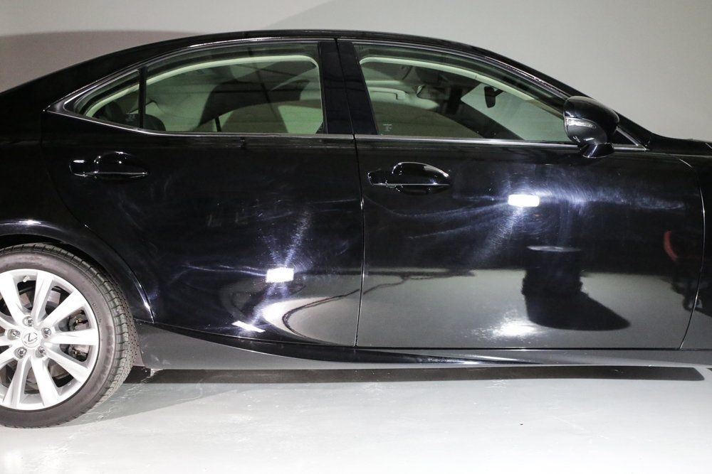 Black car with shiny paint, parked inside a garage.