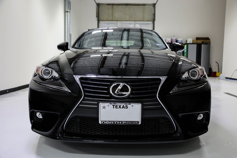 Black Lexus sedan parked in a well-lit garage; Texas license plate visible.