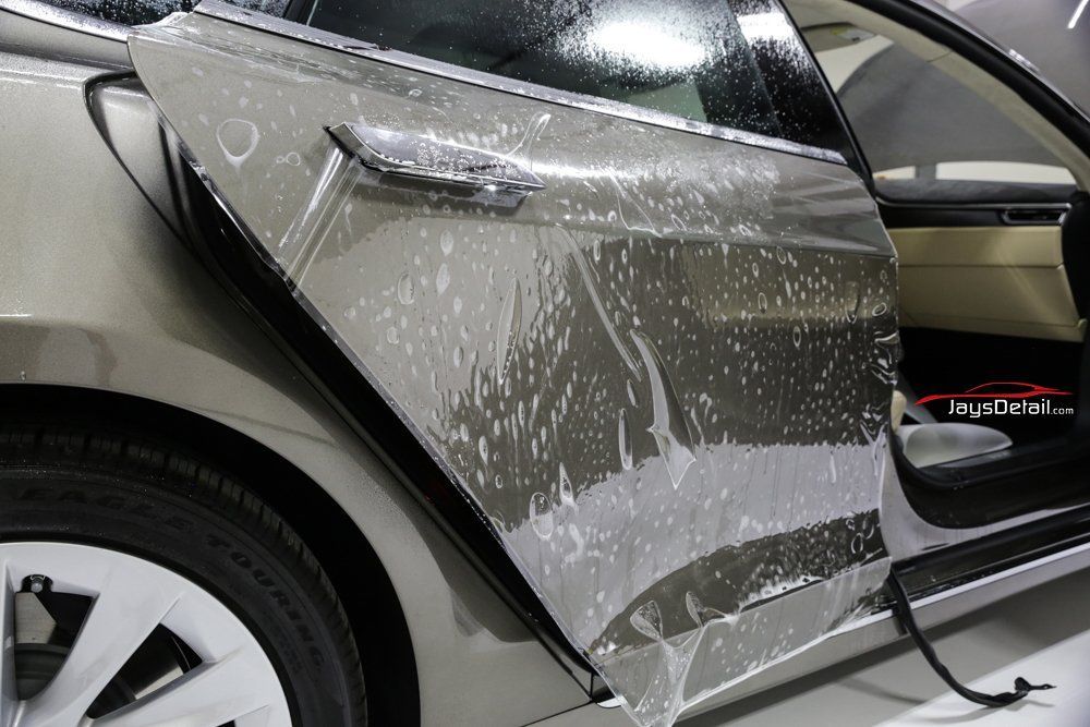 Car door with protective film being applied.