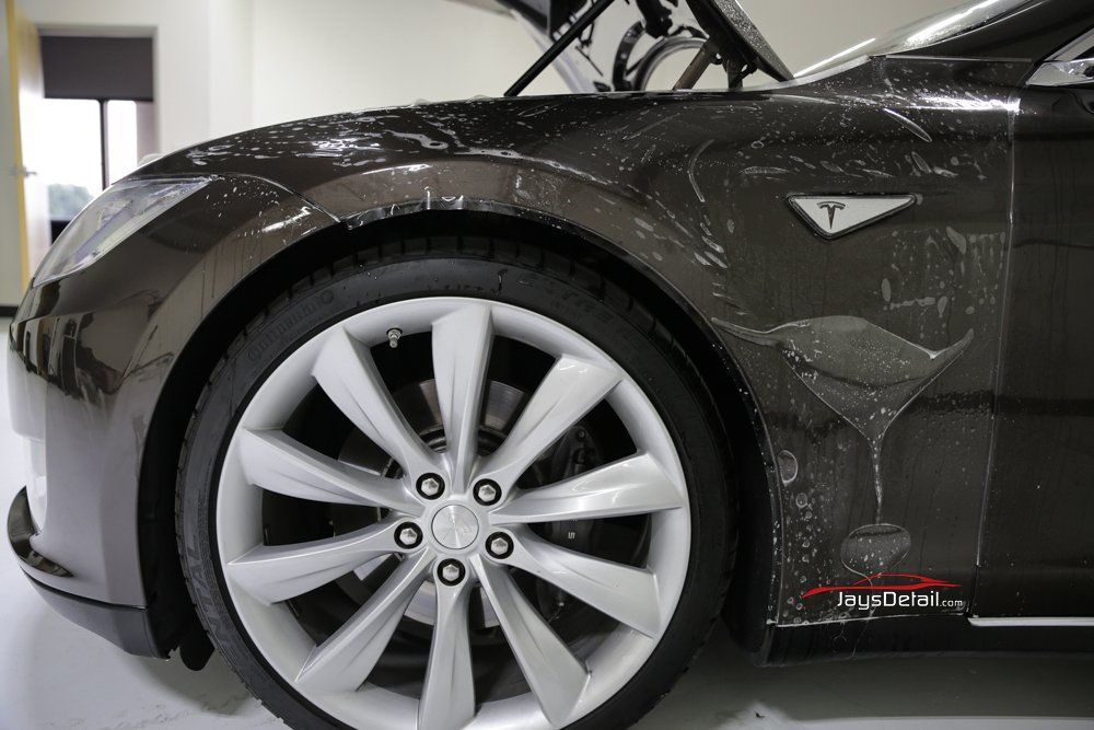Tesla car with protective film on the front fender and hood.
