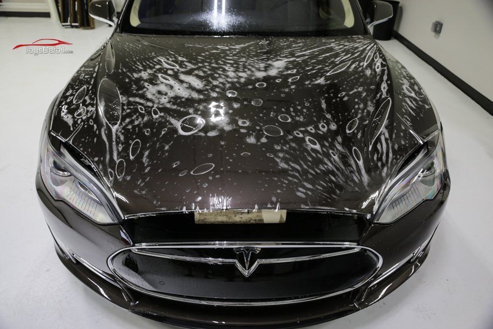 Brown Tesla with protective film applied to hood.