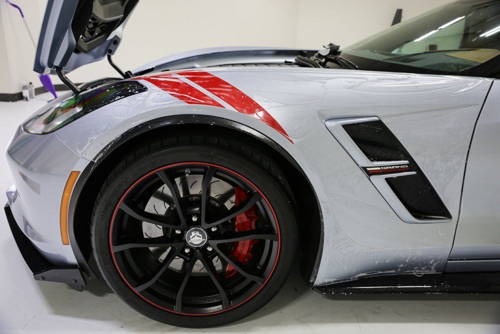 Silver Corvette sports car with red accents, hood open.