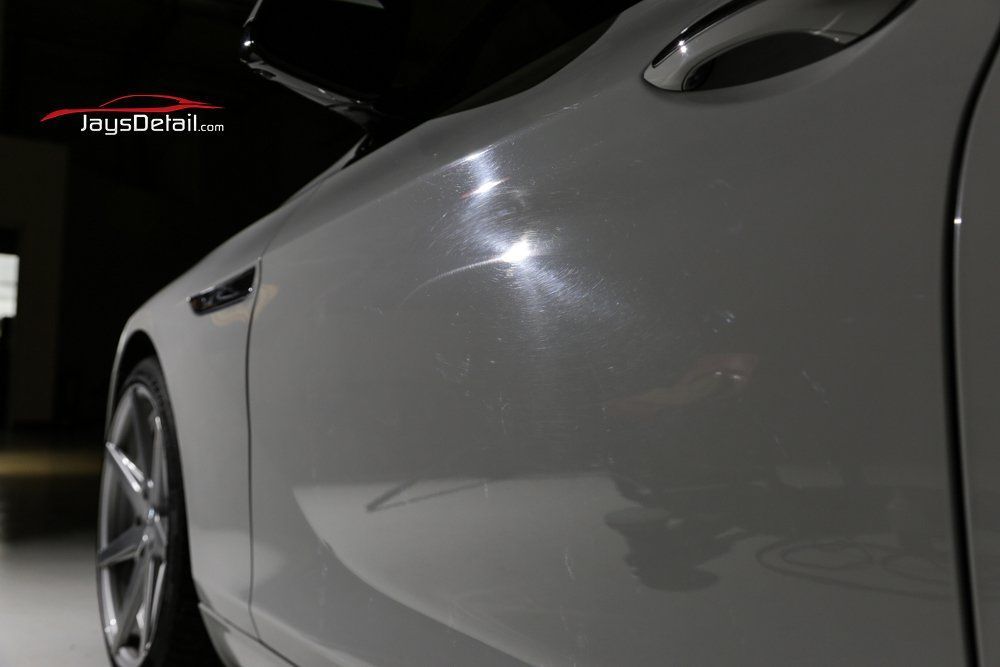 White sports car door with reflective paint; close-up detail.