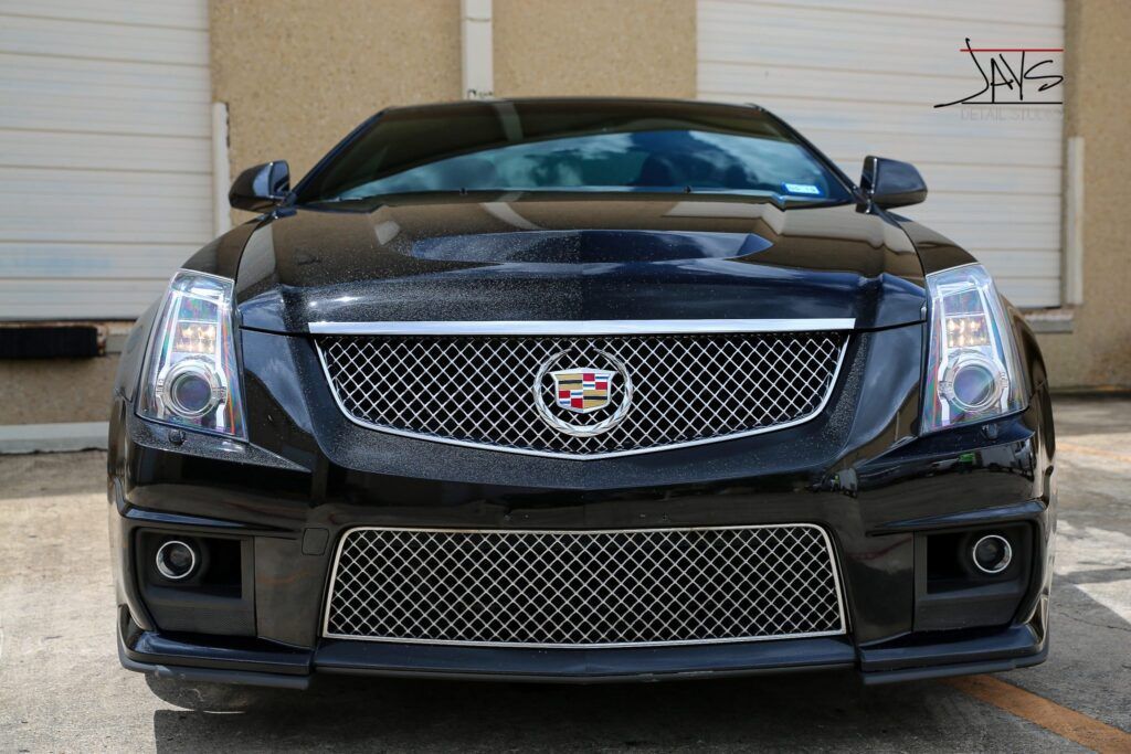 Black Cadillac CTS-V, front view, parked in front of a light-colored garage door.