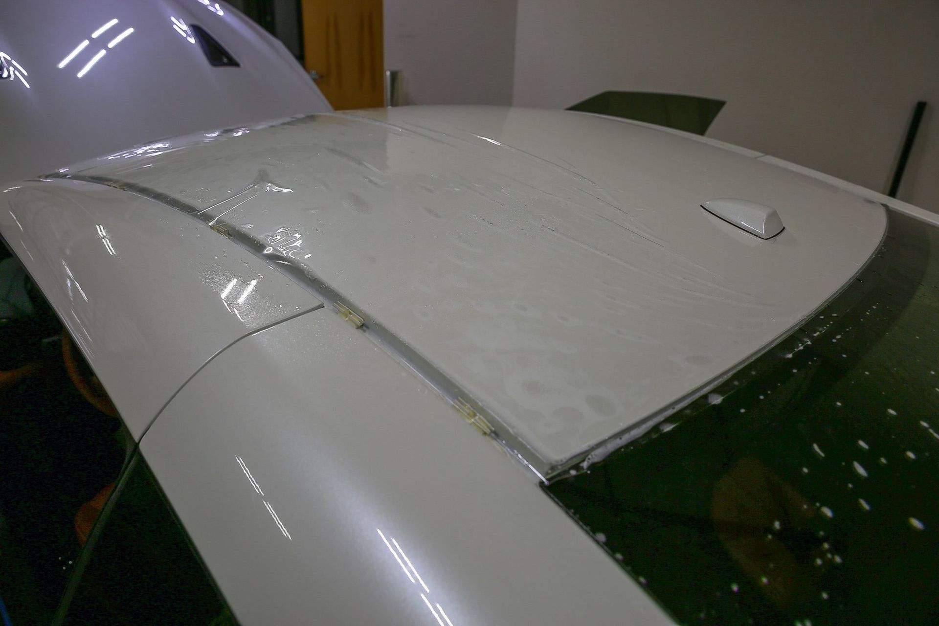 White car roof, showing edge detailing, possibly with paint protection film applied.