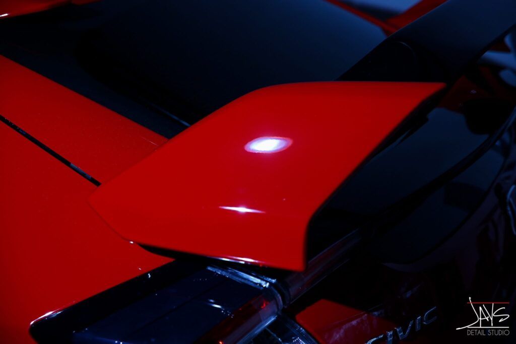 Red car hood detail with a shiny, reflective surface.