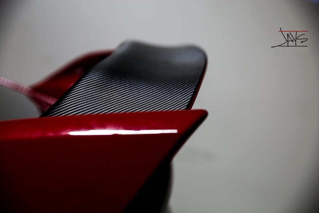 Red car with black carbon fiber spoiler.